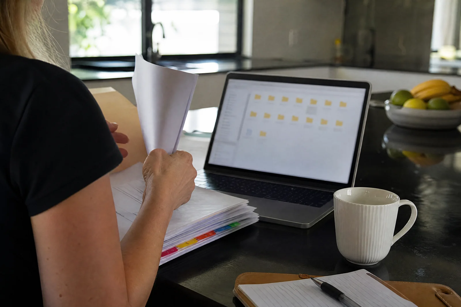 Owner scanning contracts and financial records into a laptop at home