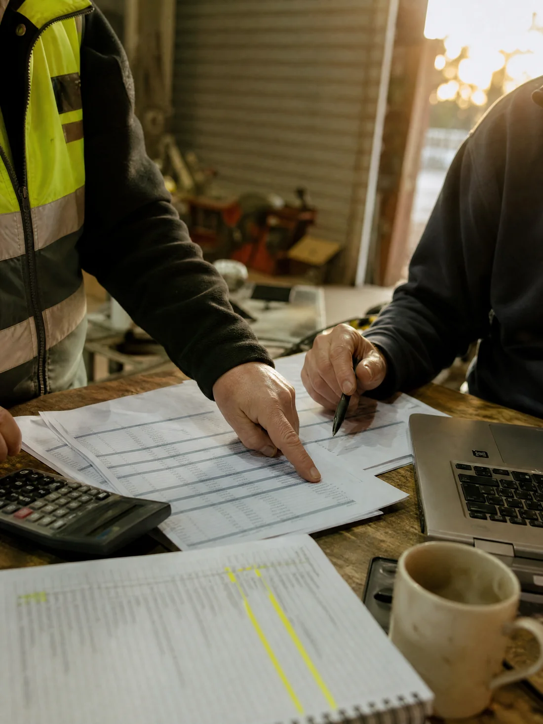 A broker and an owner checking financial statements against a readiness checklist on a workbench